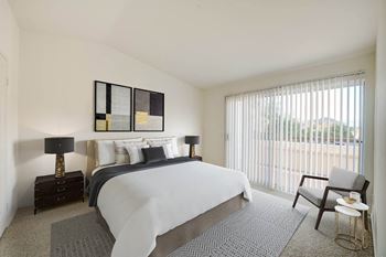 a bedroom with a bed and a chair in a room
